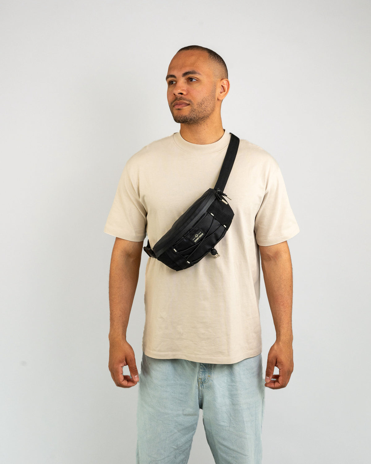 Mann trägt schwarze Bauchtasche 'Devin' von Johnny Urban quer über den Oberkörper