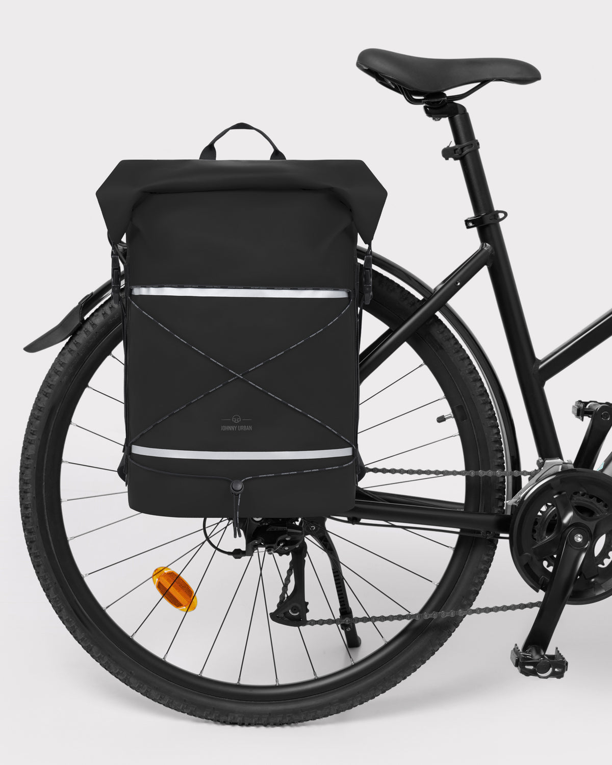 Schwarzer Rolltop Rucksack 'Myles' von Johnny Urban am Gepäckträger eines Fahrrads befestigt