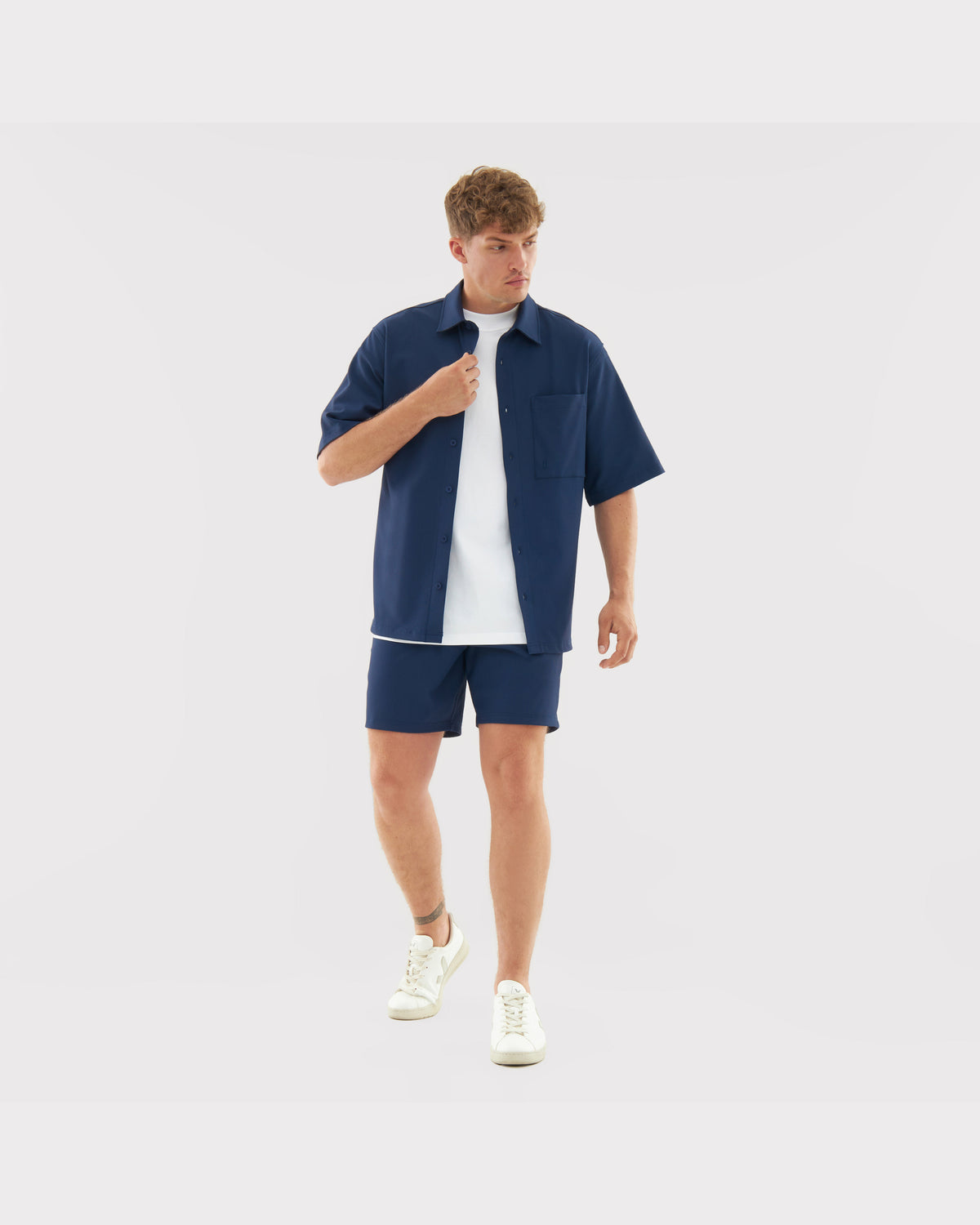 Mann trägt lässiges navyblaues Hemd mit kurzer Hose und weißem T-Shirt Set 'Mason'