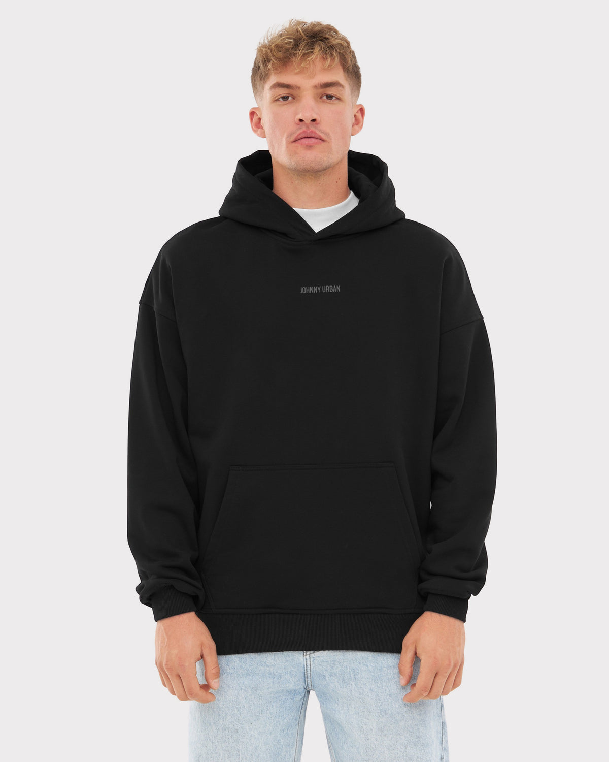 Mann trägt schwarzen oversized Hoodie 'Cody' mit Johnny Urban Print und heller Jeans