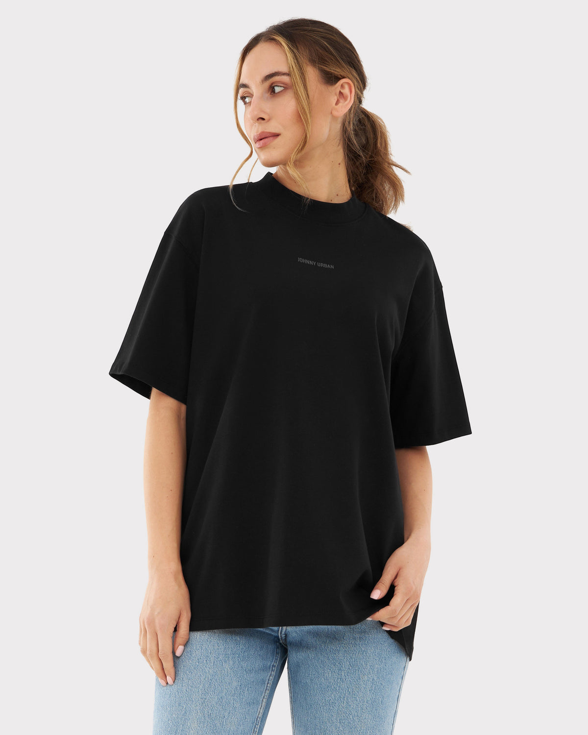 Damen trägt oversized schwarzes T-Shirt 'Sammy Johnny Urban' mit kurzem Arm und Jeans