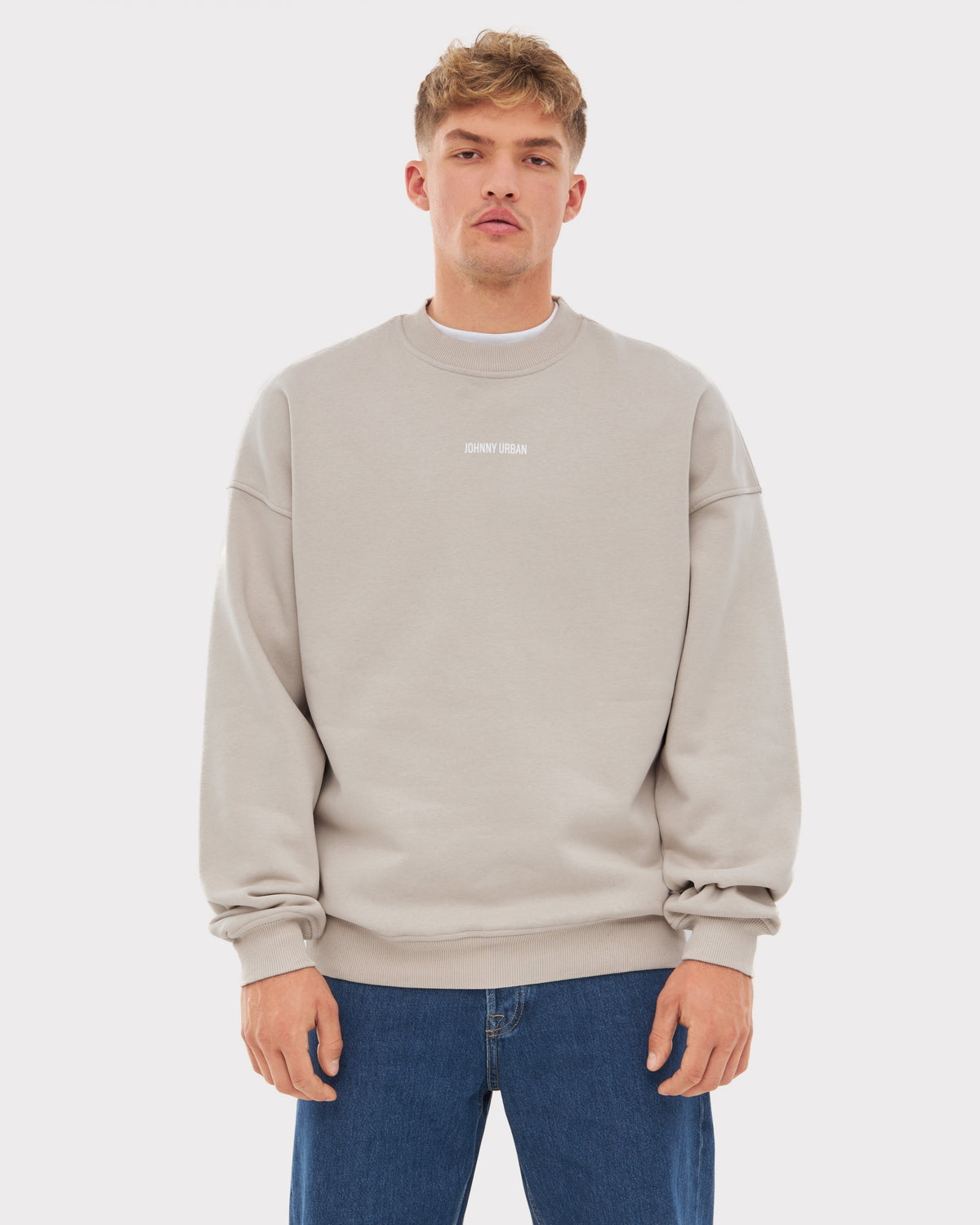 Mann trägt oversized Pullover 'Carter' von Johnny Urban in Beige mit kleinem Logo in der Mitte