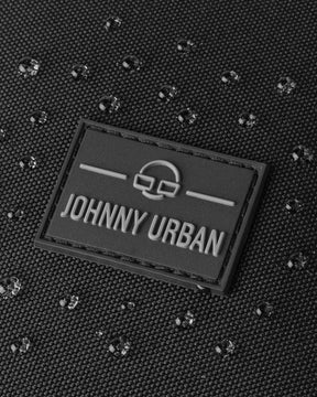 Nahaufnahme des Logos von Johnny Urban auf dem wasserfesten Stoff des Rucksacks ‚Nico‘ mit Wassertropfen
