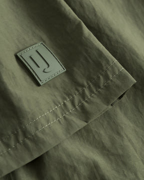 Detailaufnahme der olivgrünen Badehose 'Jay' mit einem rechteckigen Logo-Label
