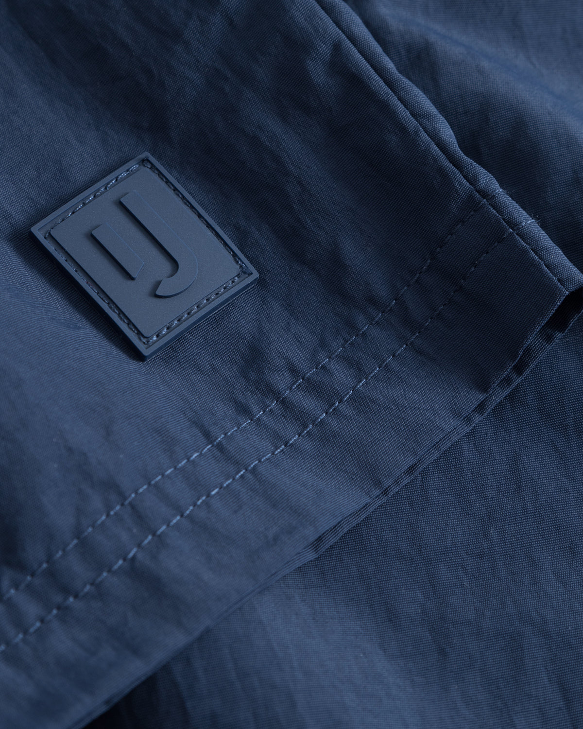 Nahaufnahme der navyblauen Badehose 'Jay' mit Johnny Urban Logo-Patch