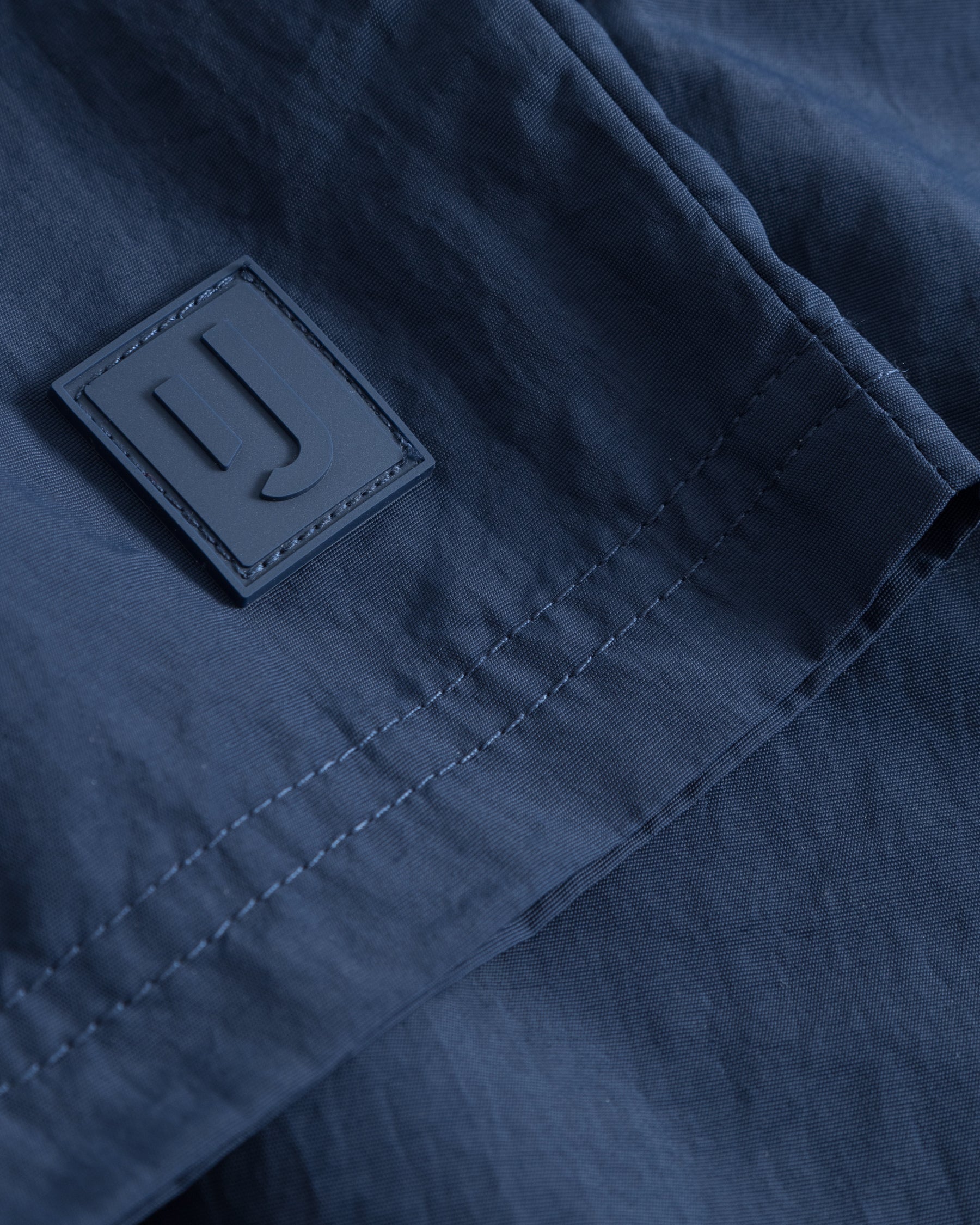 Nahaufnahme der navyblauen Badehose 'Jay' mit Johnny Urban Logo-Patch