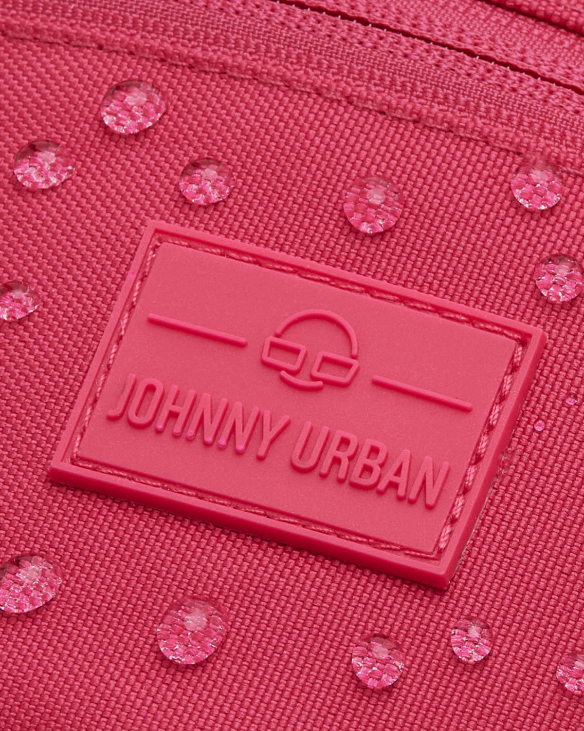 Nahaufnahme der pinken Bauchtasche ‚Erik Small‘ von Johnny Urban mit sichtbaren Wassertropfen auf dem Material
