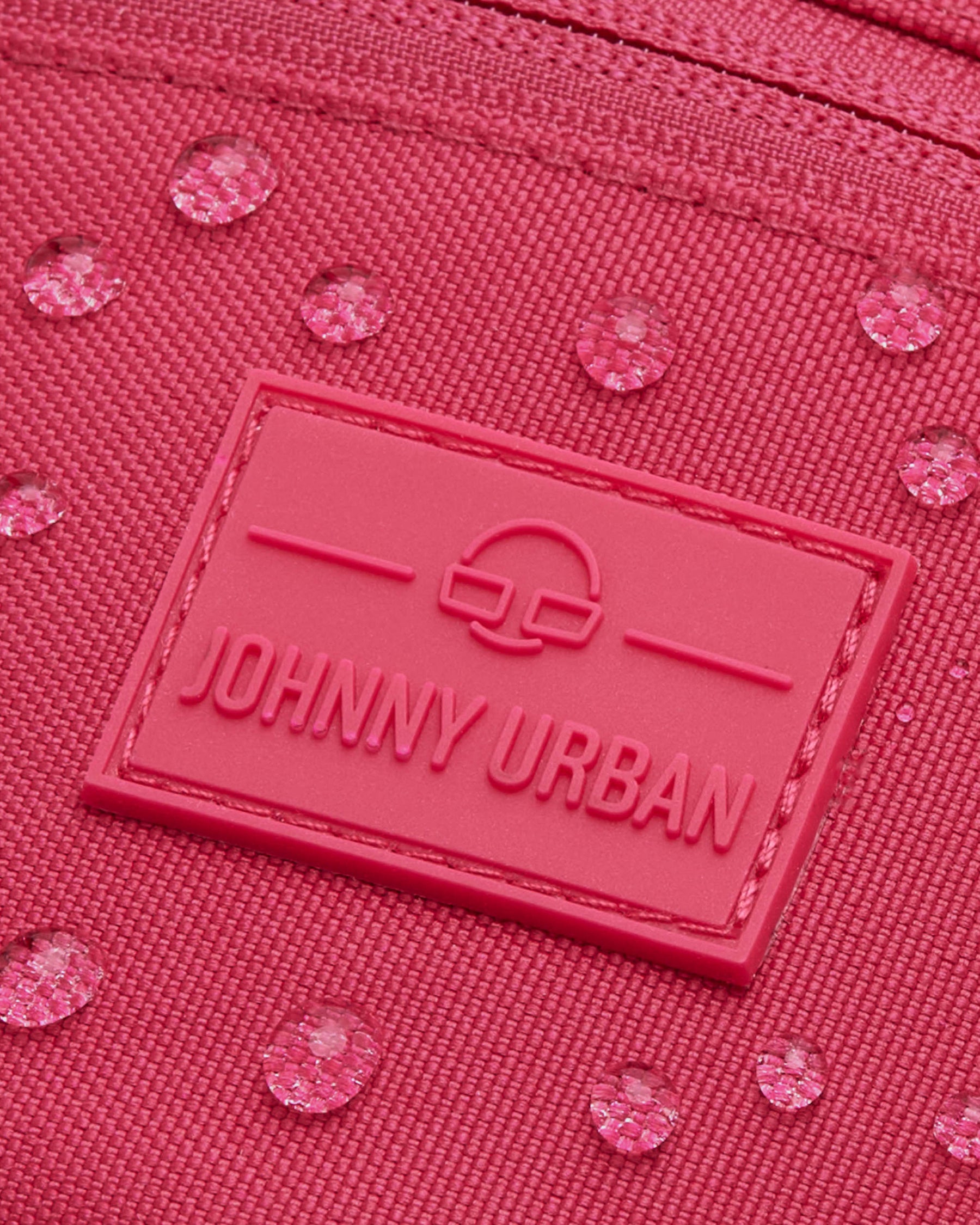 Nahaufnahme der pinken Bauchtasche ‚Erik Small‘ von Johnny Urban mit sichtbaren Wassertropfen auf dem Material