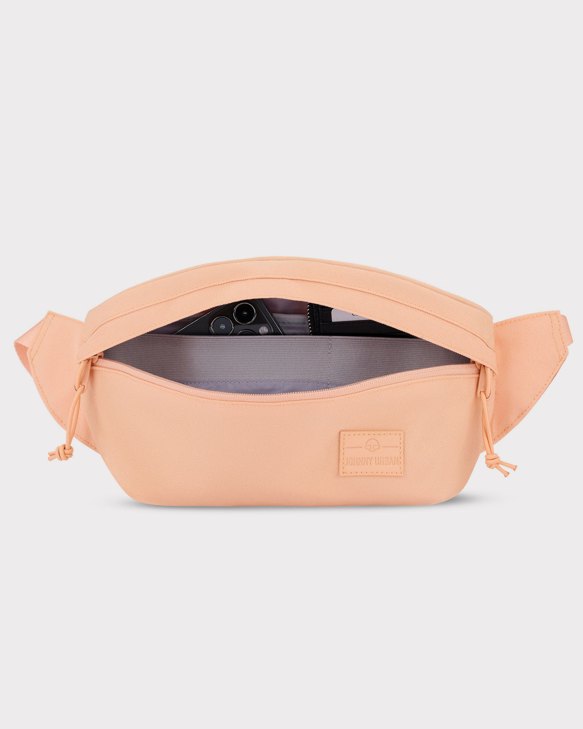 Pfirsichfarbene Bauchtasche 'Tom' von Johnny Urban mit geöffnetem Reißverschluss und sichtbarem Smartphonefach