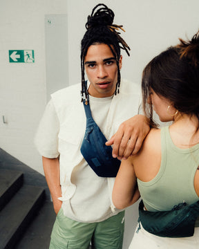 Junger Mann trägt Bauchtasche 'Erik Small' von Johnny Urban in Blau quer über die Brust