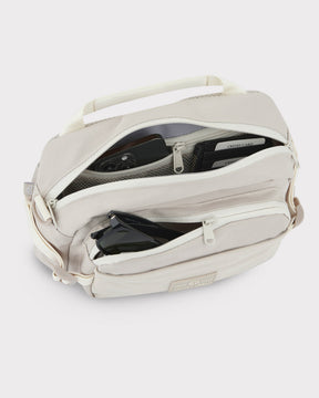 Beige Bauchtasche 'Travis' von Johnny Urban mit mehreren Reißverschlussfächern, gefüllt mit Smartphone, Sonnenbrille und Kreditkartenetui
