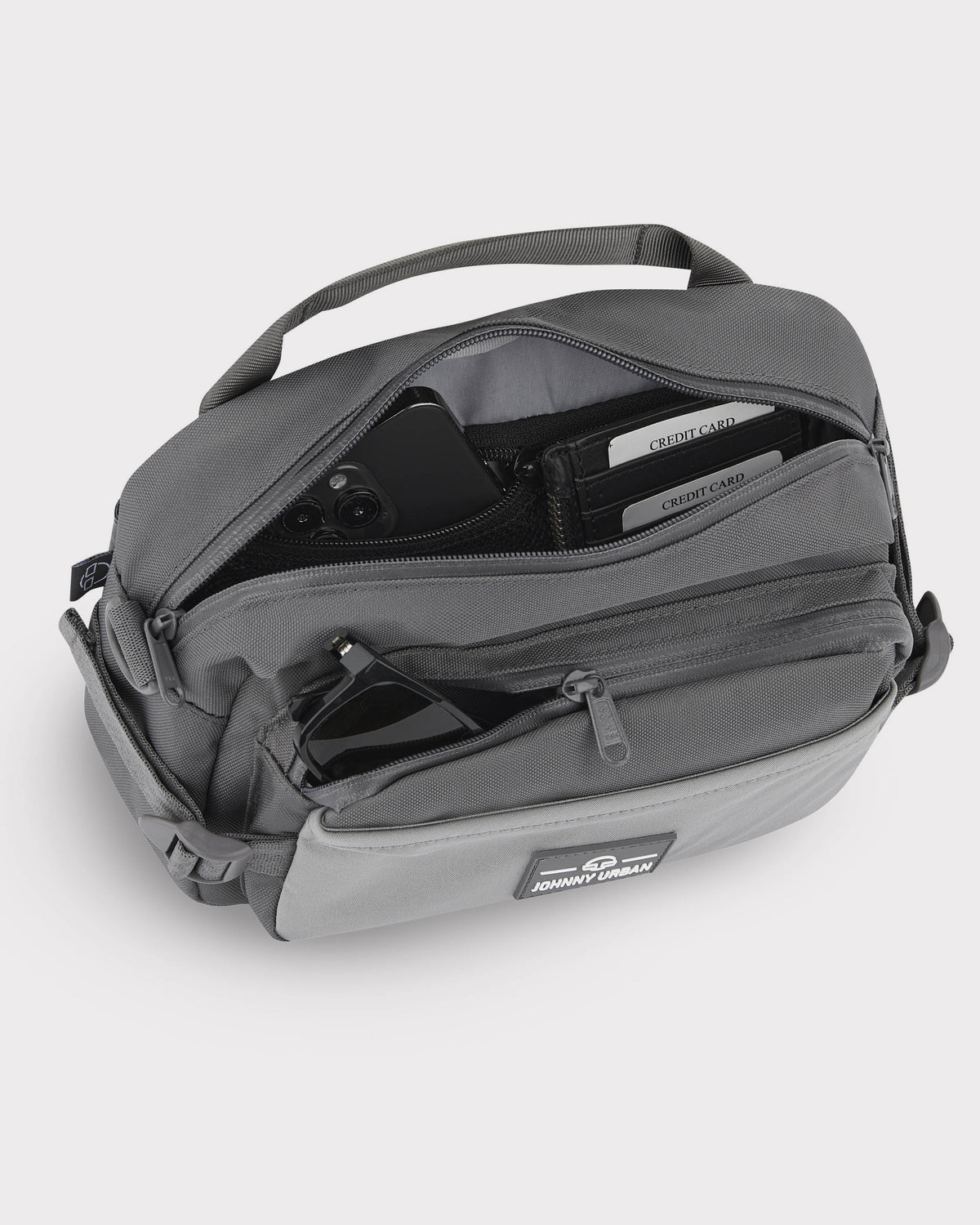 Große graue Bauchtasche 'Travis' von Johnny Urban mit offenem Hauptfach, sichtbaren Kreditkartenfächern und Sonnenbrille in der Fronttasche