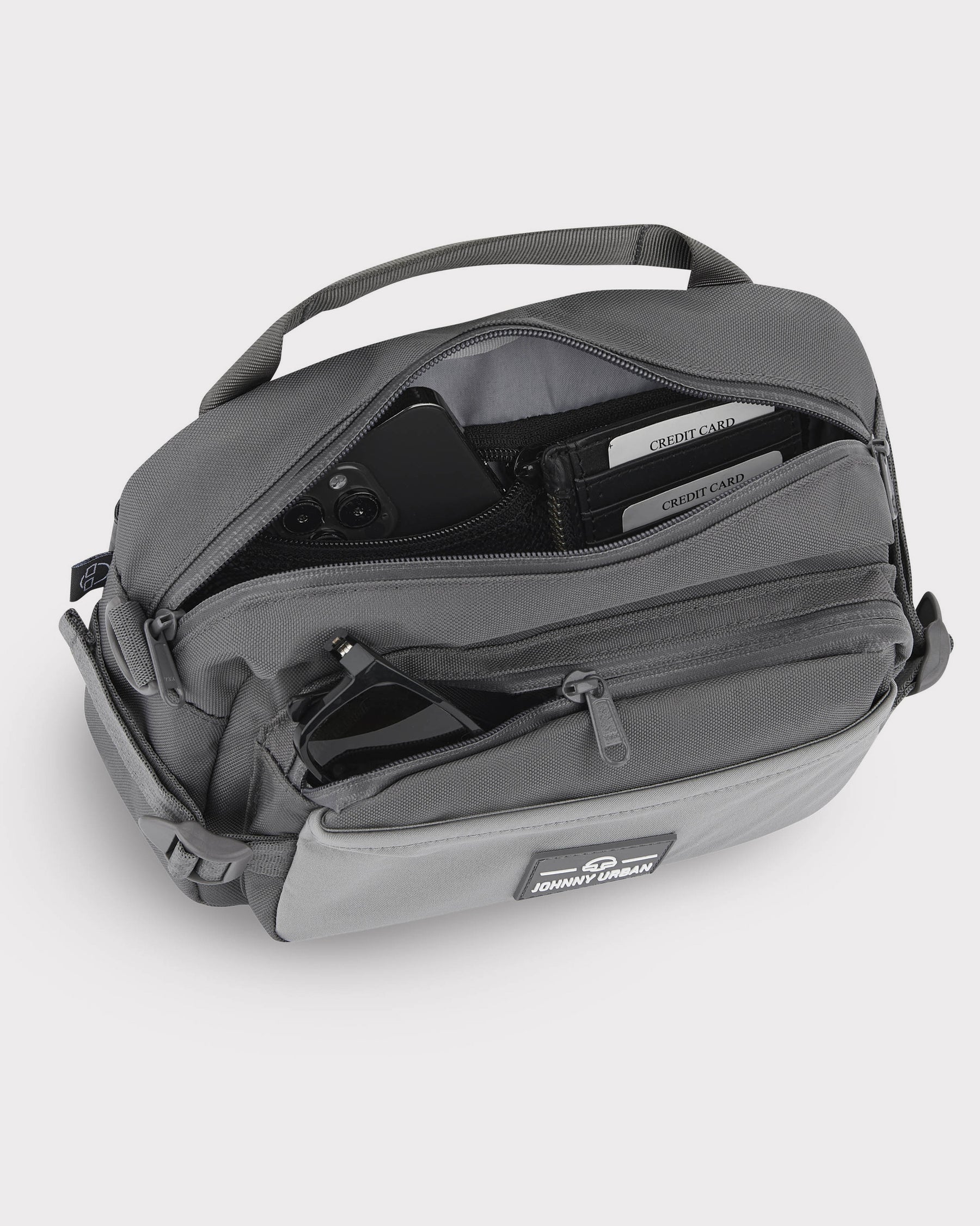 Große graue Bauchtasche 'Travis' von Johnny Urban mit offenem Hauptfach, sichtbaren Kreditkartenfächern und Sonnenbrille in der Fronttasche
