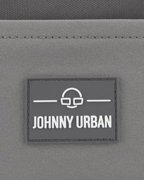 Graues Logo mit dem Text 'Johnny Urban' auf der nachhaltigen Bauchtasche 'Travis'