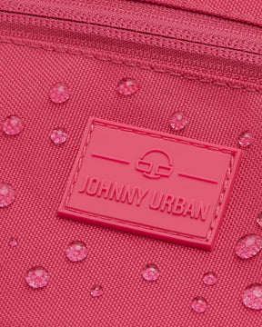 Nahaufnahme der wasserabweisenden pinkfarbenen Bauchtasche 'Ben' von Johnny Urban mit Logo-Patch und Wassertropfen