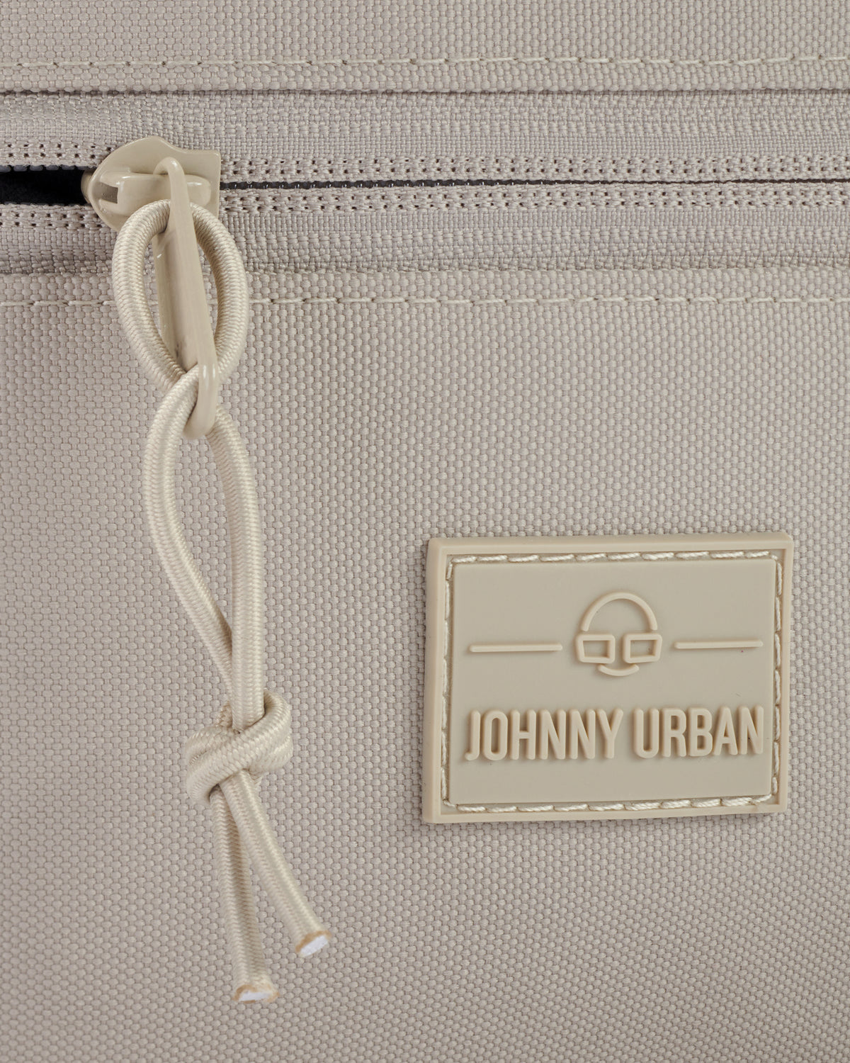 Nahaufnahme des Reißverschlusses und des Johnny Urban Logos der Bauchtasche 'Erik Large' in Sandbeige