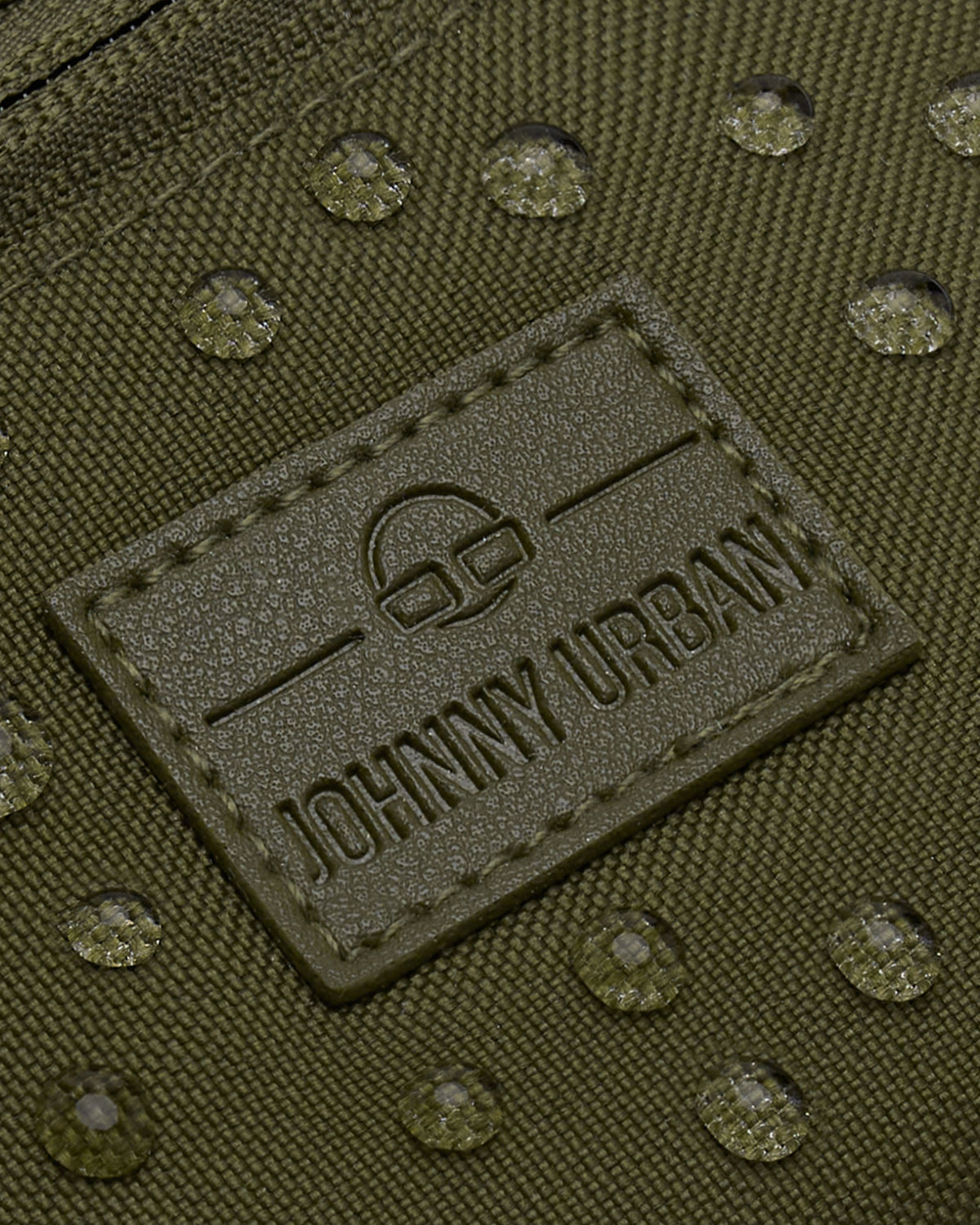 Nahaufnahme der wasserabweisenden Oberfläche und des Markenlabels der olivgrünen Bauchtasche 'Erik Small' von Johnny Urban