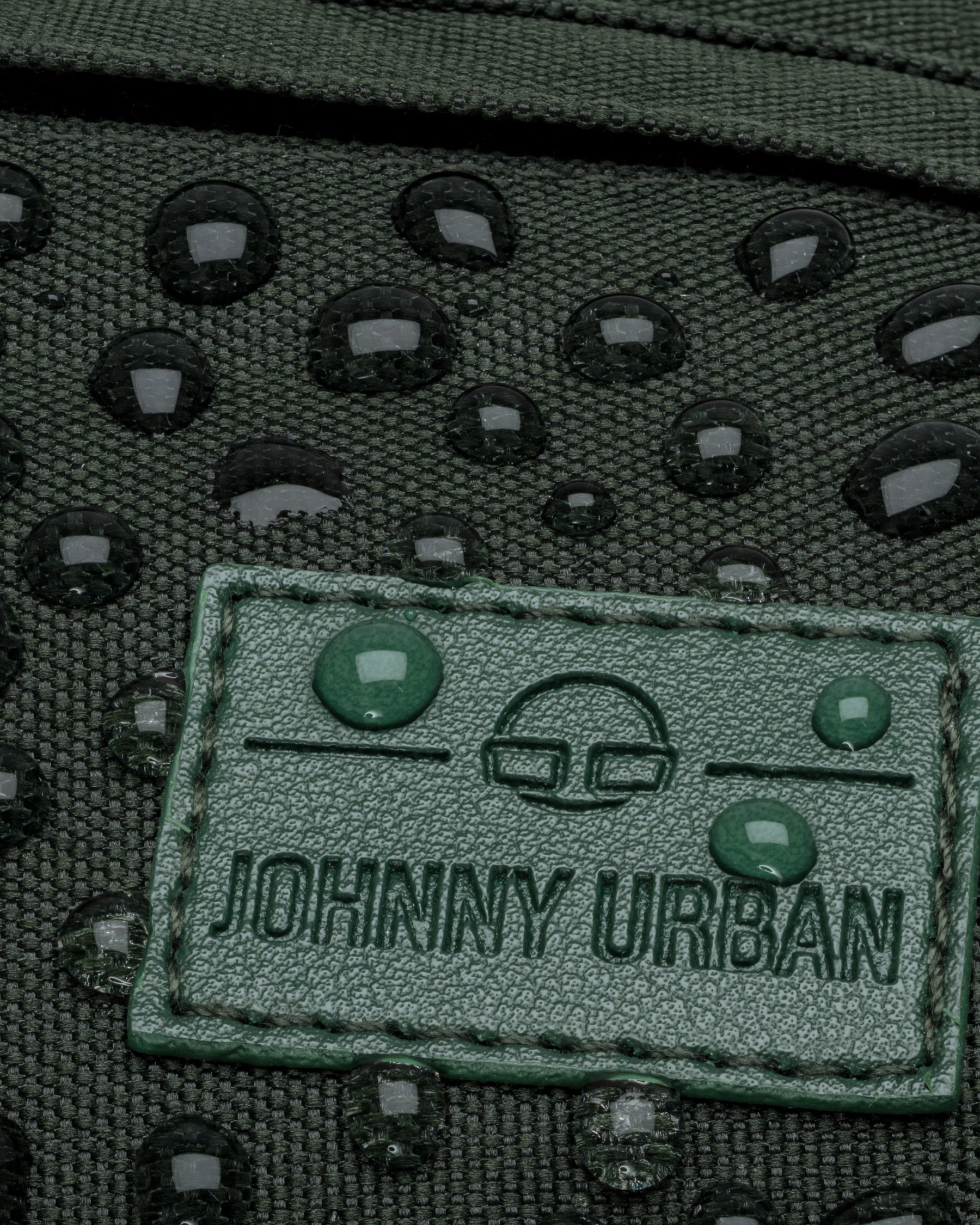 Wasserabweisende grüne Bauchtasche 'Tom' von Johnny Urban mit Wassertropfen auf dem Logo-Patch
