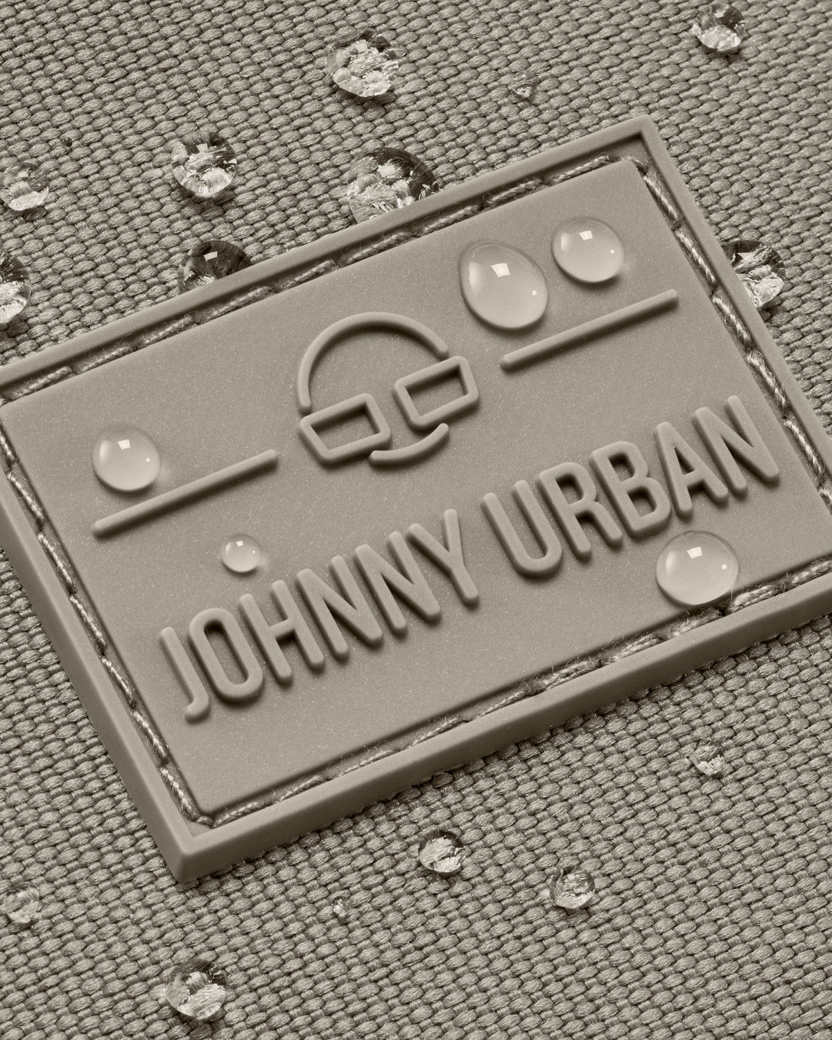 Wasserdichte Textiloberfläche mit Johnny Urban Logo und Wassertropfen