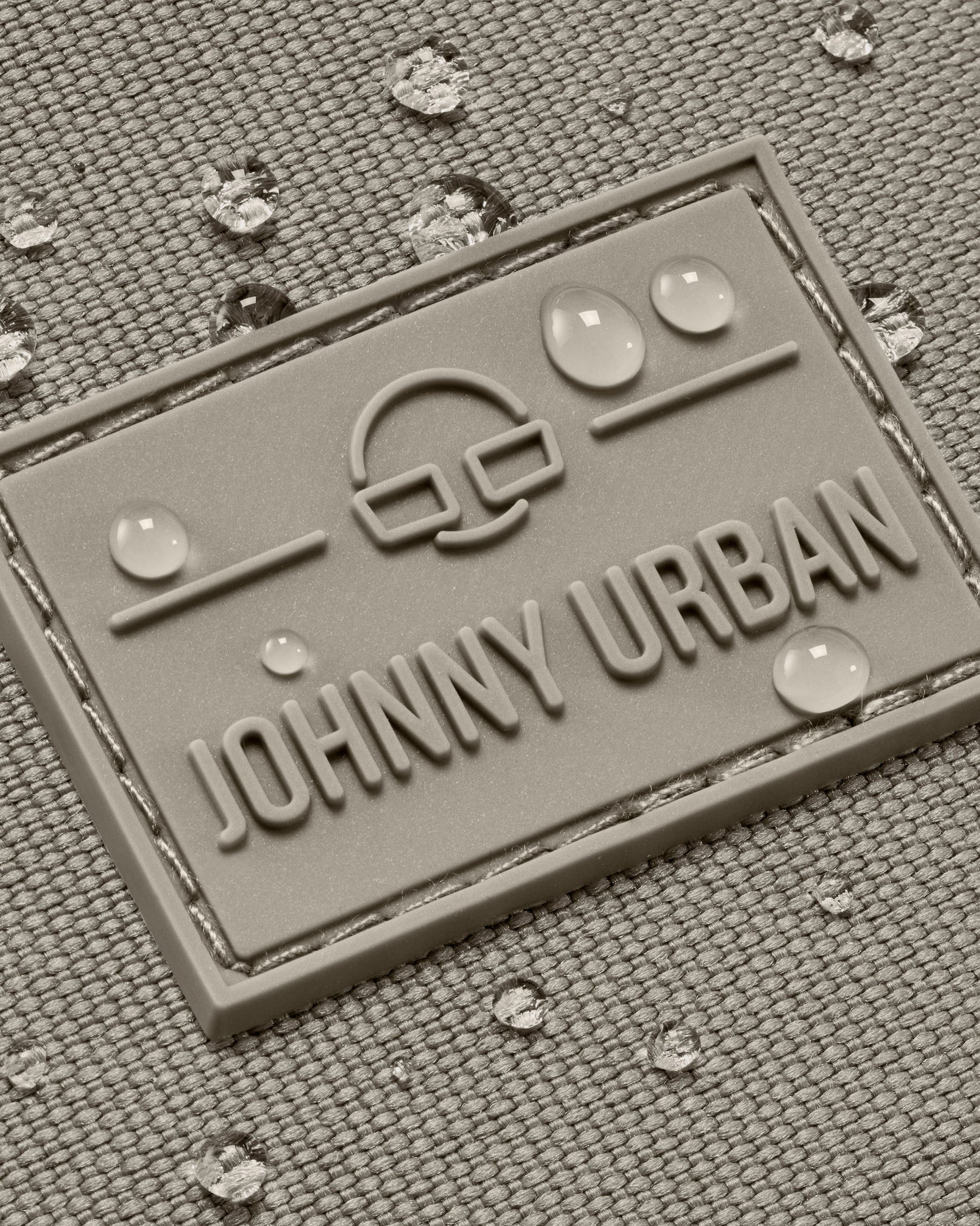 Wasserdichte Textiloberfläche mit Johnny Urban Logo und Wassertropfen