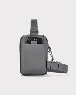 Dunkelgraue Brusttasche 'Arthur' von Johnny Urban mit Vorderfach, in dem ein Smartphone steckt