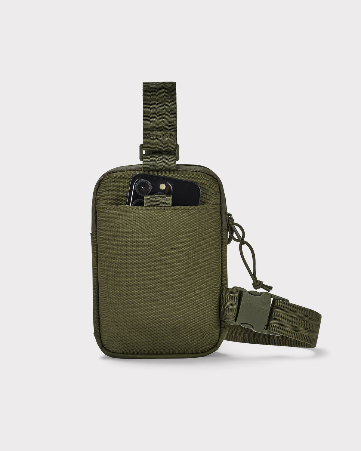 Olivegrüne Brusttasche 'Arthur' mit Fronttasche, in der ein Smartphone steckt