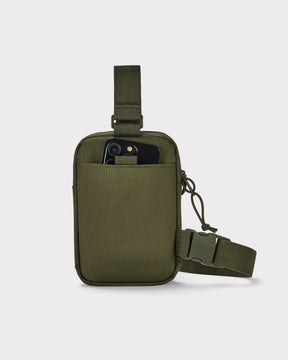 Olivegrüne Brusttasche 'Arthur' mit Fronttasche, in der ein Smartphone steckt