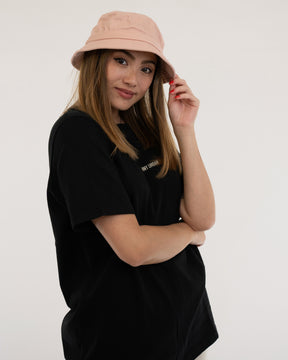 Frau trägt rosa Bucket Hat 'Gill' und schwarzes Johnny Urban T-Shirt