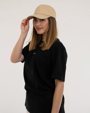 Frau mit mittellangen braunen Haaren trägt die sandfarbene Damen-Cap 'Jen' von Johnny Urban und ein schwarzes T-Shirt