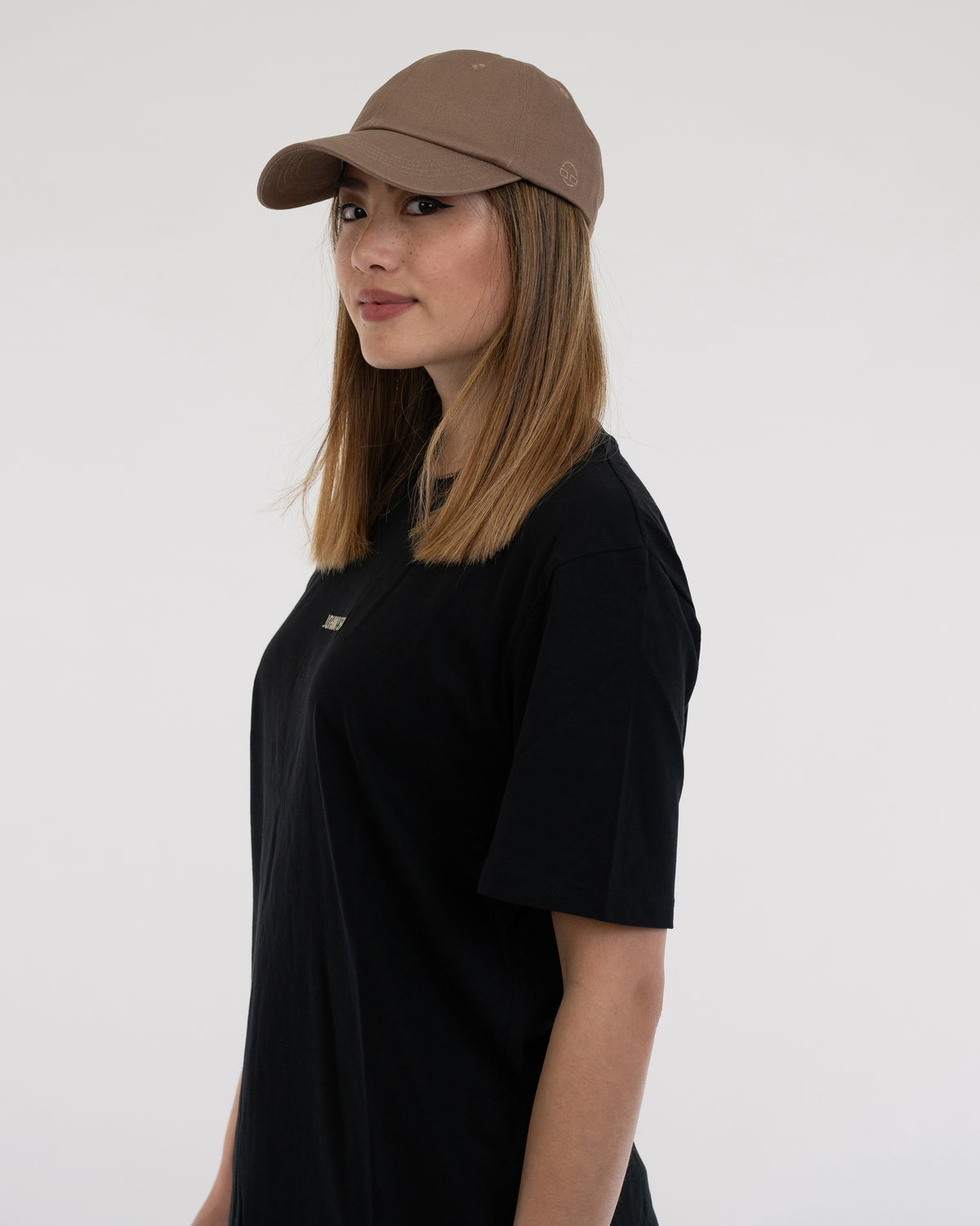 Frau mit brauner Cap 'Jen' und schwarzem T-Shirt, Seitenprofil