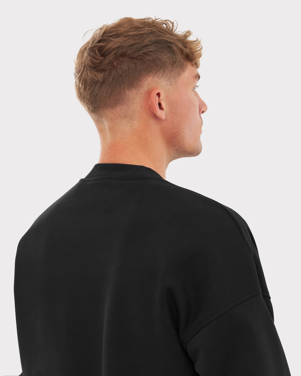 Mann von hinten mit schwarzem oversized Crewneck 'Carter' von Johnny Urban