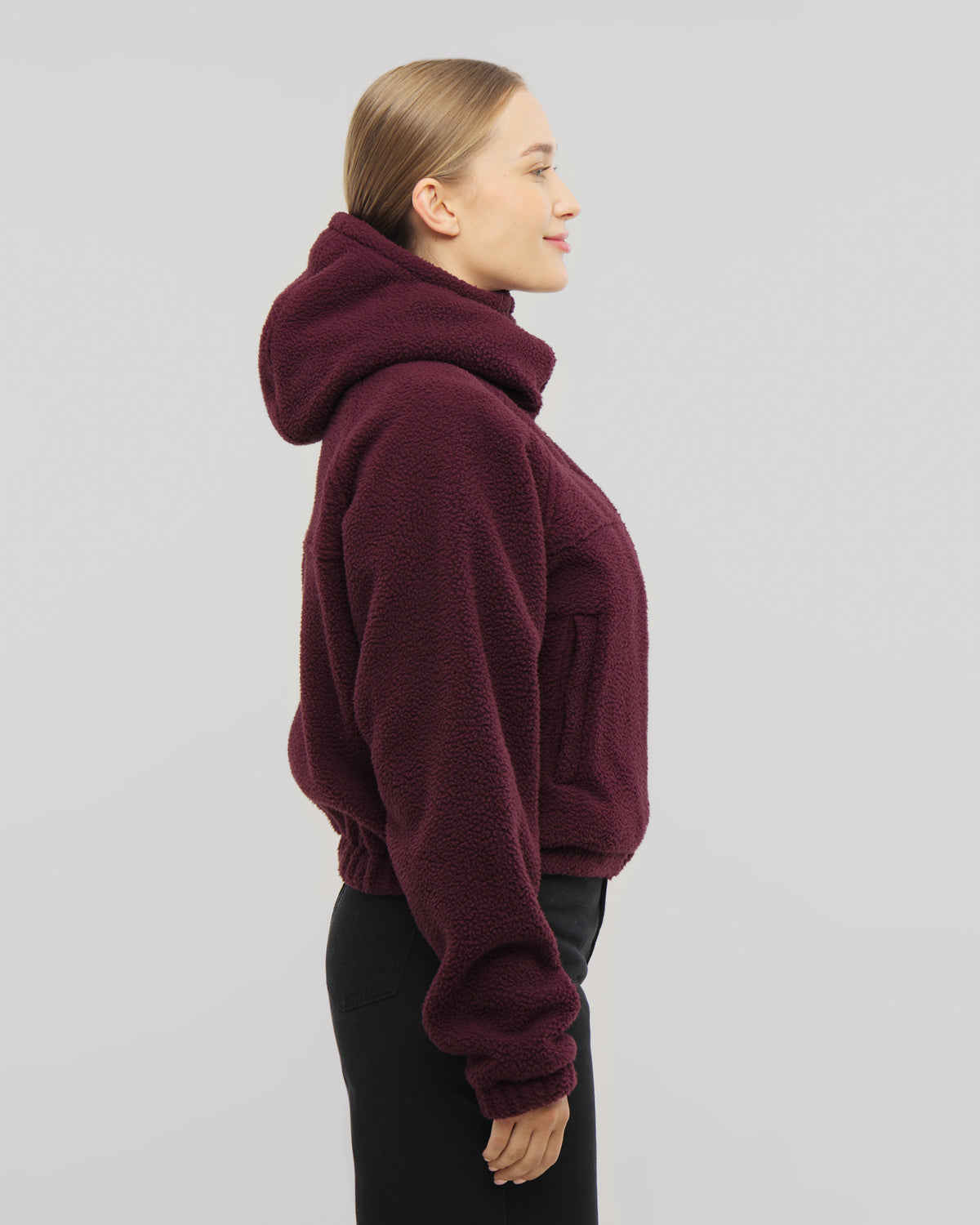 Die Fleecejacke Nova in burgunderrot mit Druckknöpfen in den Seitentaschen für eine sichere Aufbewahrung all deiner Essentials. 