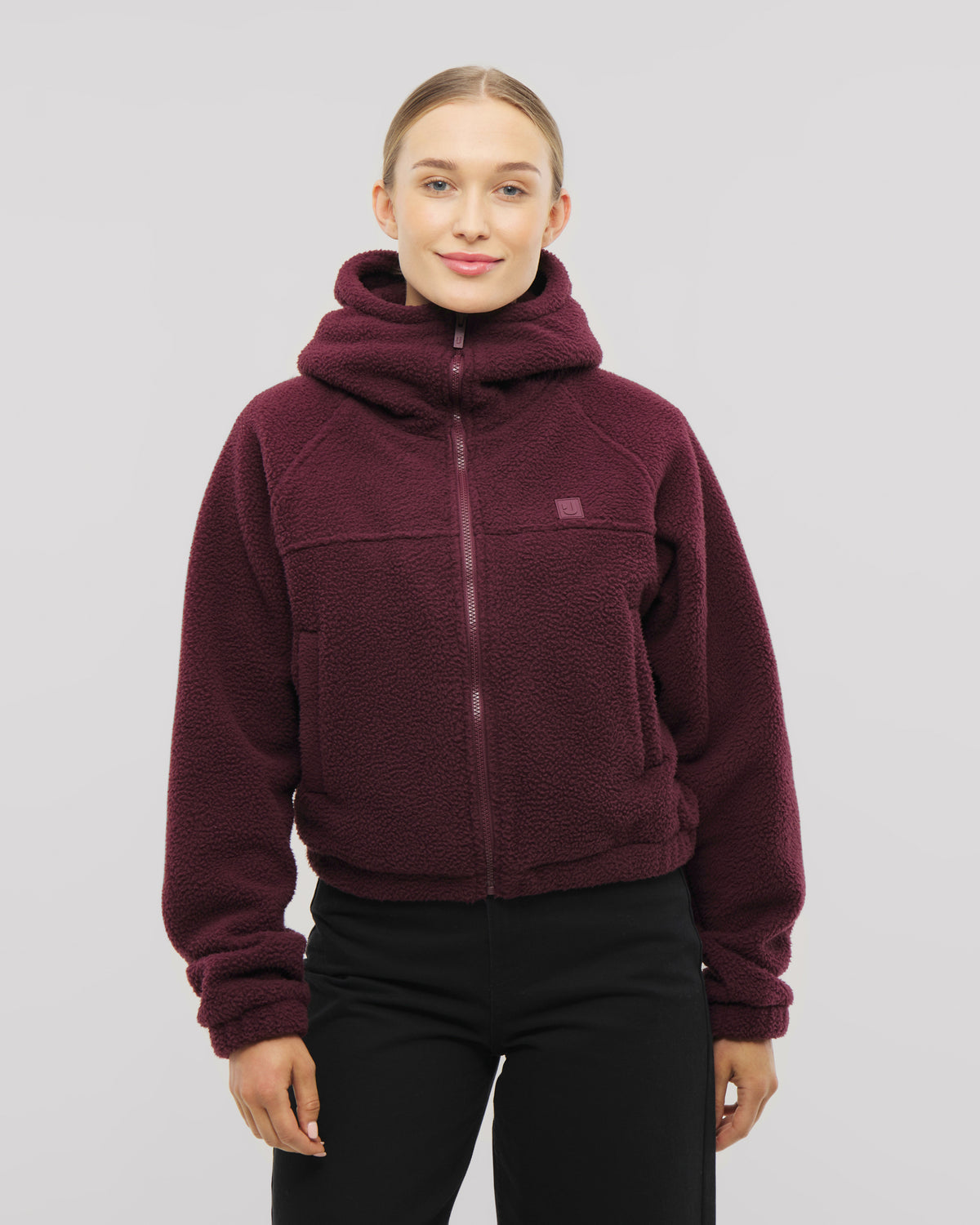 Nova ist unsere Fleecejacke für Damen - hier in Burgunderrot mit hoher Kapuze. 