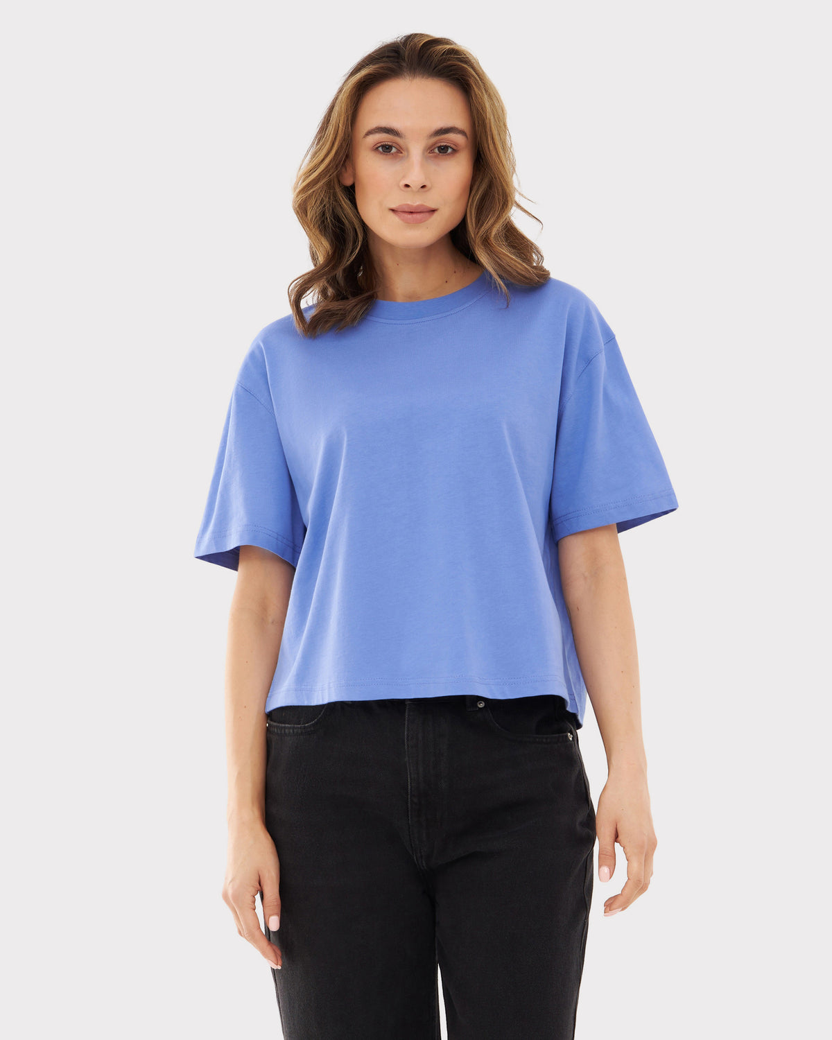 Frau trägt blaulila oversized Cropped T-Shirt 'Zoey JU' mit schwarzen Jeans