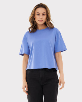 Frau trägt blaulila oversized Cropped T-Shirt 'Zoey JU' mit schwarzen Jeans