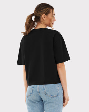 Frau von hinten in schwarzem Cropped T-Shirt 'Zoey' und blauer Jeans