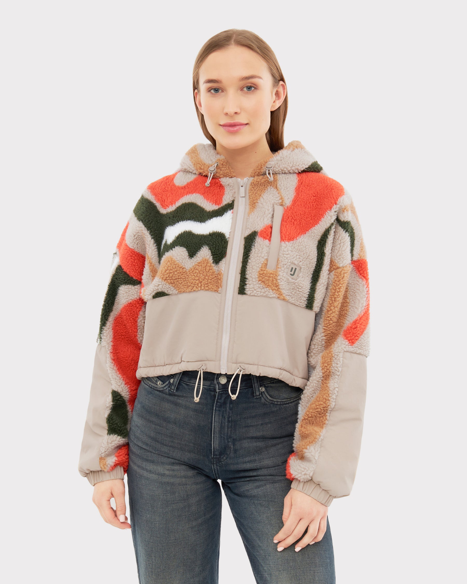 Frau trägt Cropped Teddy Fleecejacke "Carey" mit buntem abstraktem Print und beigen Details