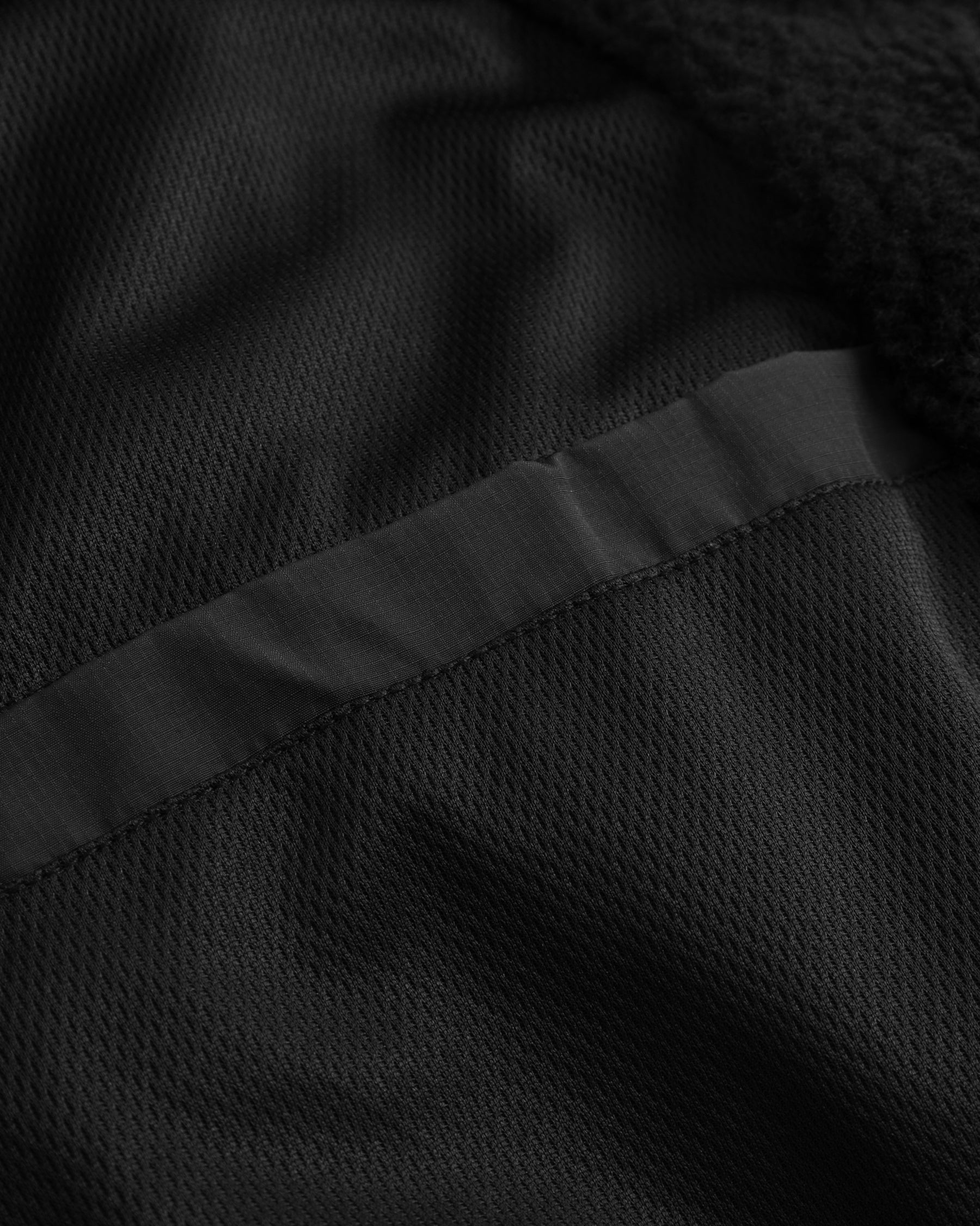 Nahe Ansicht der schwarzen Taschenöffnung der Cropped Teddy Fleecejacke 'Carey'