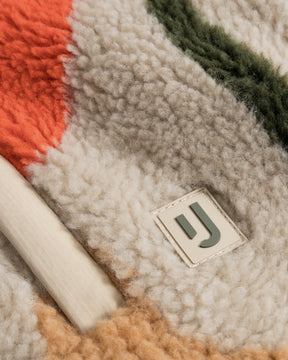 Nahaufnahme der Cropped Teddy Fleecejacke 'Carey' mit mehrfarbigem Plüsch und Johnny Urban Logo