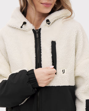 Frau trägt weiße und schwarze Cropped Teddy Fleecejacke 'Carey' mit Kapuze und Reißverschluss