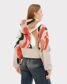 Frau trägt Cropped Teddy Fleecejacke 'Carey' mit Kapuze in buntem abstraktem Muster von hinten
