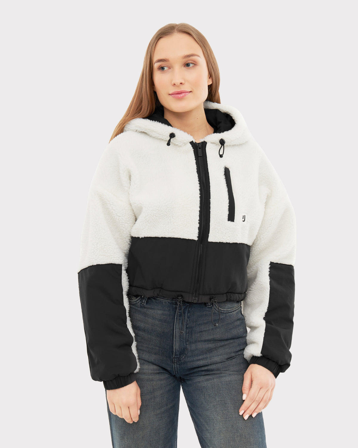 Frau trägt weiße und schwarze Cropped Teddy Fleecejacke 'Carey' mit Kapuze und Reißverschluss