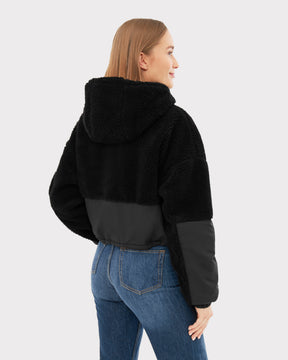 Rückansicht einer Frau in schwarzer Cropped Teddy Fleecejacke 'Carey' mit Kapuze und blauer Jeans