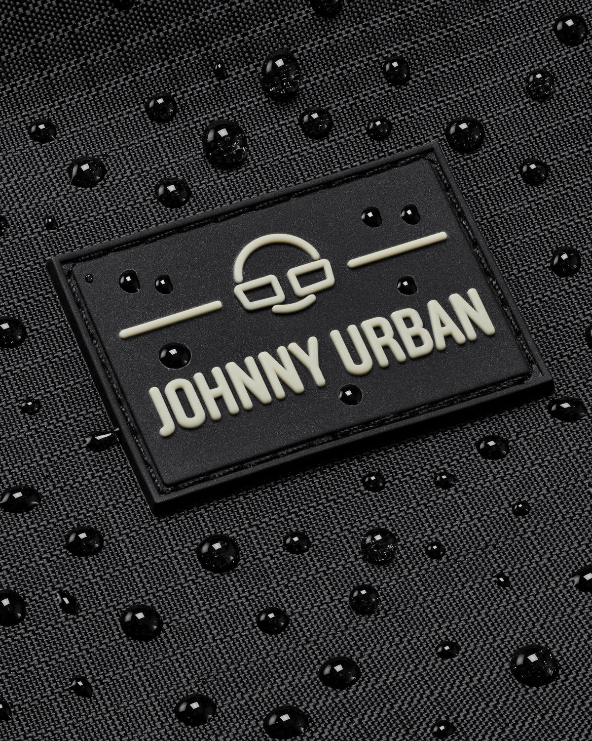 Schwarzes, wasserabweisendes Material mit Johnny Urban Logo und Wassertröpfchen