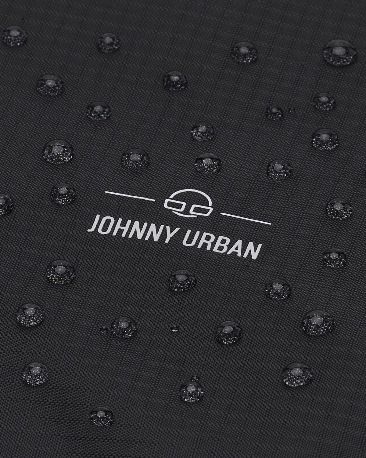 Wasserabweisender schwarzer Stoff mit weißen Johnny Urban Logo und Wassertropfen