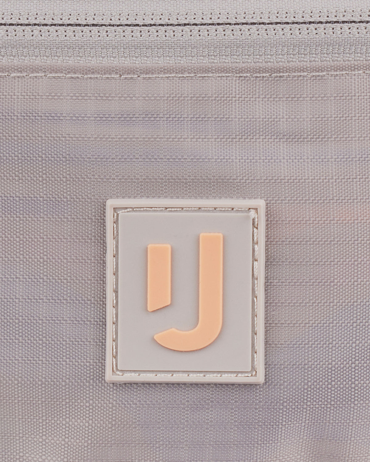 Nahe Aufnahme des Logos auf der wasserabweisenden 2in1 Bauchtasche 'Jimmy' von Johnny Urban