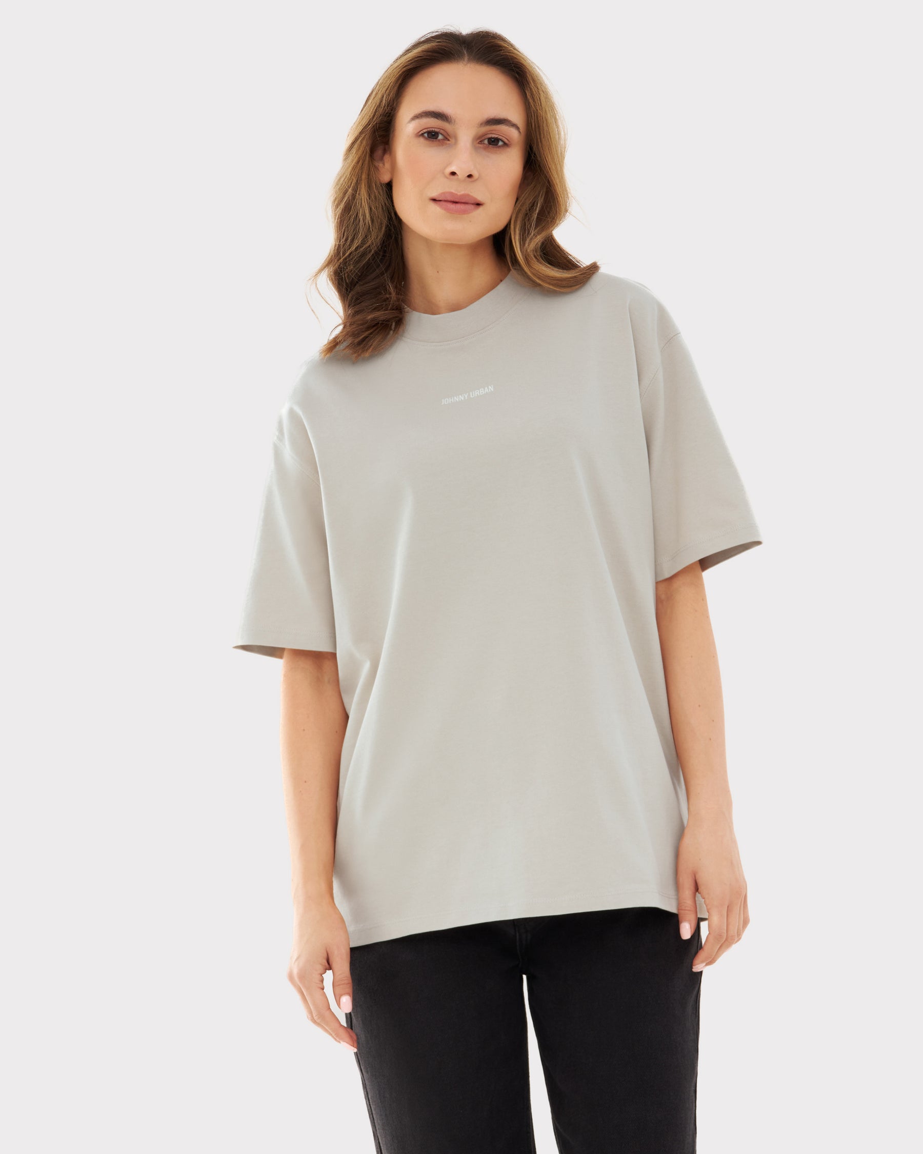 Frau trägt beige oversized T-Shirt 'Sammy Johnny Urban' mit kurzem Ärmel und schwarzer Hose