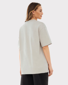 Frau trägt sandfarbenes Oversized-T-Shirt 'Sammy Johnny Urban' von hinten gesehen