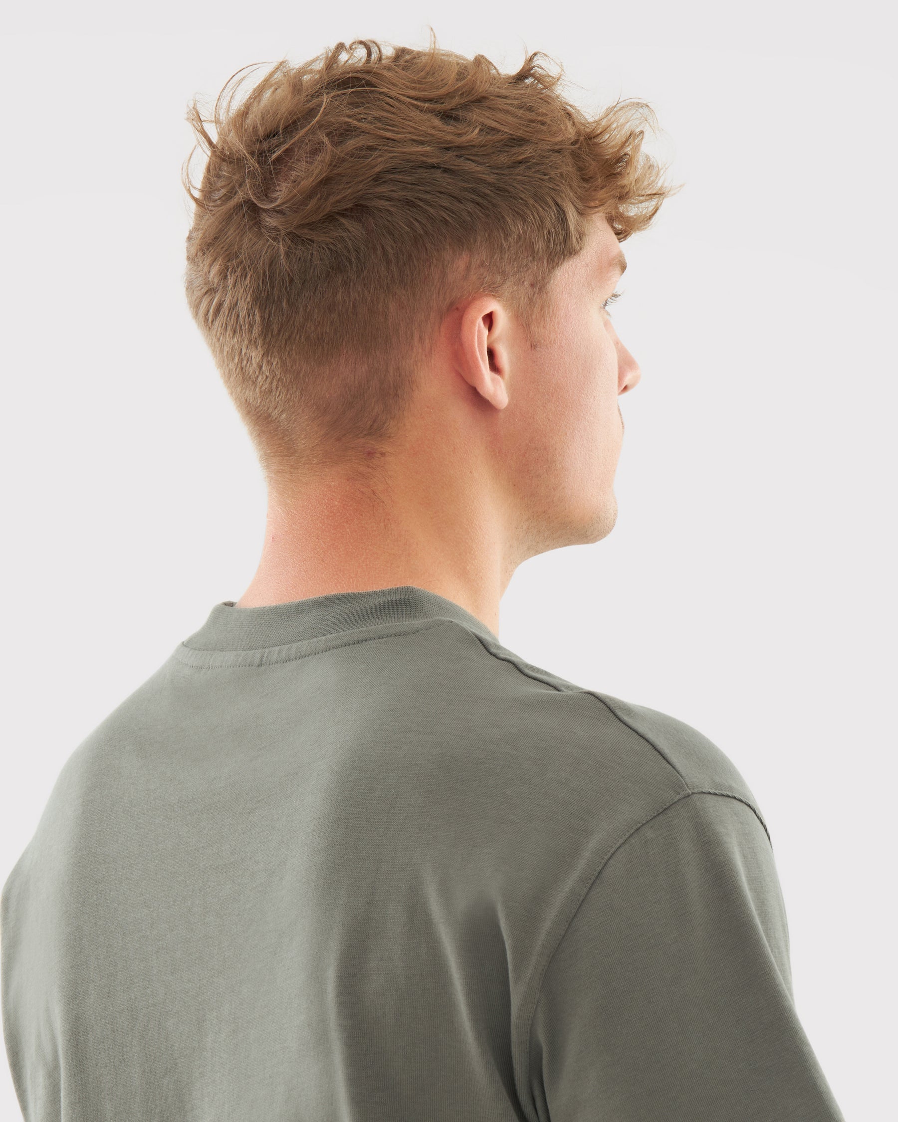 Rückansicht eines Mannes mit kurzem braunem Haar, getragenes olivgrünes T-Shirt 'Sammy' von Johnny Urban