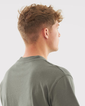 Rückansicht eines Mannes mit kurzem braunem Haar, getragenes olivgrünes T-Shirt 'Sammy' von Johnny Urban
